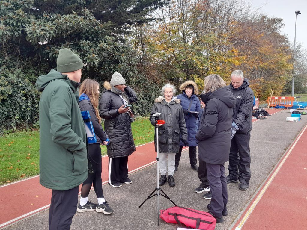 A group of KCAA field officials learning about setting up and reading a wind gauge